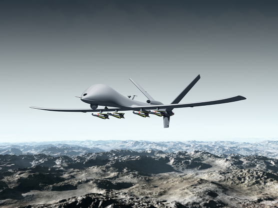 Military drone flying over a mountain range