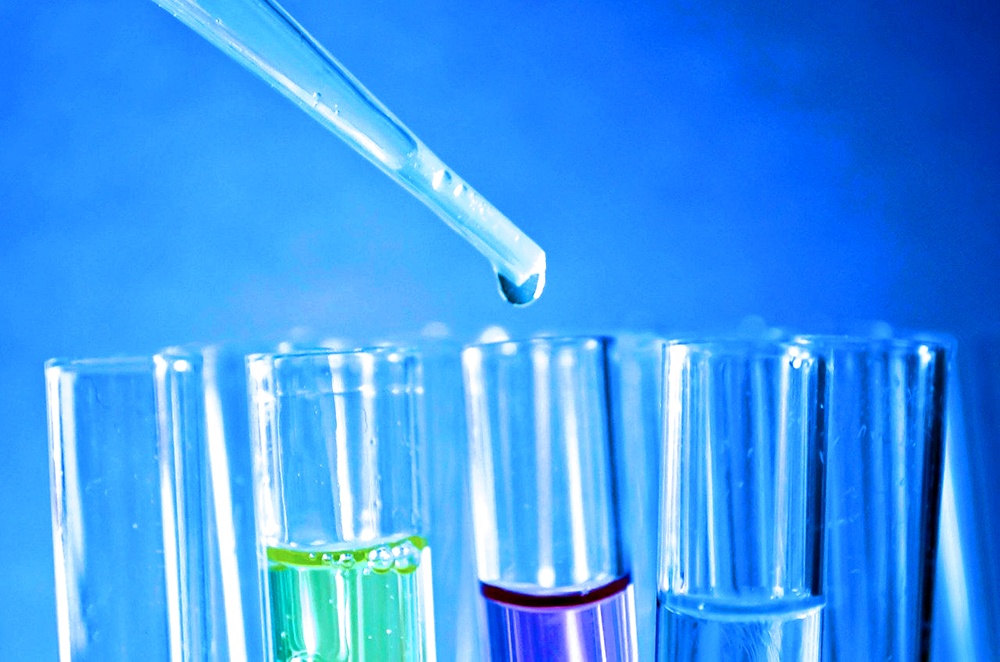 Filled fluid beakers in front of a blue background