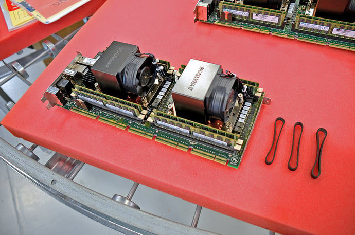 A dual-CPU processor board with banded DIMMs next to three hold-down bands
