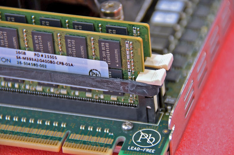 Hold-down bands circumscribing the ejector tabs of two DIMMs