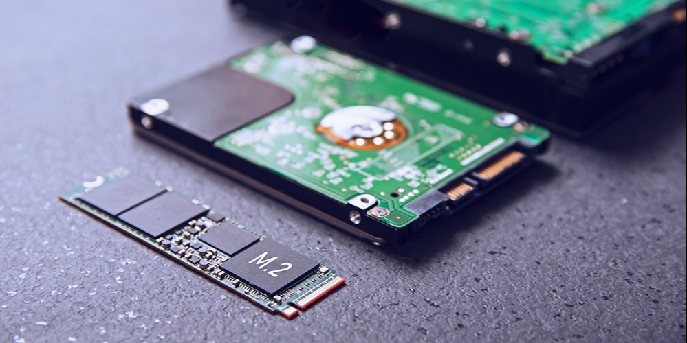 An M.2 NVMe SSD lying next to HDDs and other SSDs.