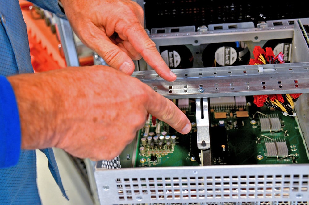 An engineer shows off a hold-down bar and one hold-down bracket